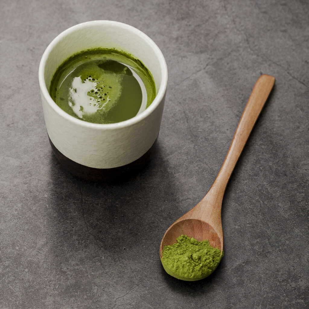 close up matcha tea cup with wooden spoon